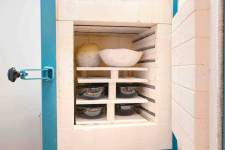 Sechs Keramikschüssel stehen übereinander im offenen Brennofen. 