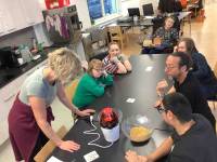 Mehrere Klienten des slw sowie Mitarbeiter sitzen gemeinsam am Tisch und arbeiten mit Karten aus der Unterstützten Kommunikation.