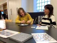 Ein Klient des slw und eine Mitarbeiterin der Lebenswelt-Tirol-Sprachwerkstatt sitzen am Tisch und schauen sich Piktogramme an. 