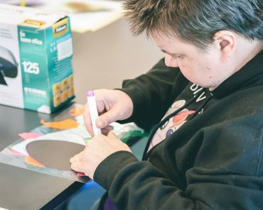 eine Frau malt auf ein Blatt