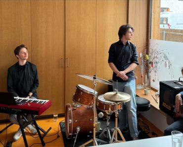 drei Musiker mit Keyboard, Schlagzeug und E-Gitarre