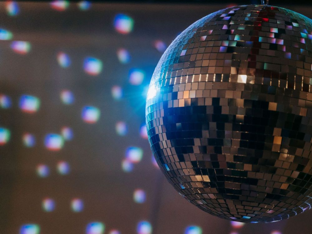 eine Discokugel macht bunte Flecken auf die gegenüber liegende Wand