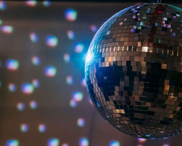 eine Discokugel macht bunte Flecken auf die gegenüber liegende Wand