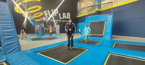 viele Trampoline in einer Halle; in der Mitte steht ein Mann