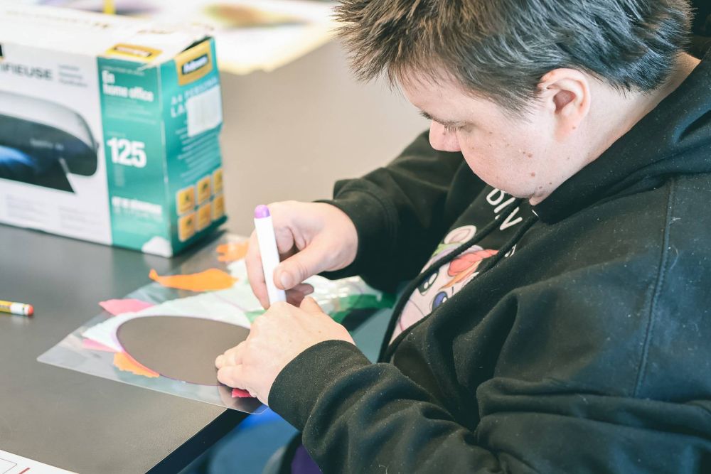 eine Frau malt auf ein Blatt