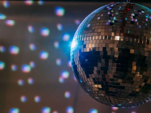 eine Discokugel macht bunte Flecken auf die gegenüber liegende Wand