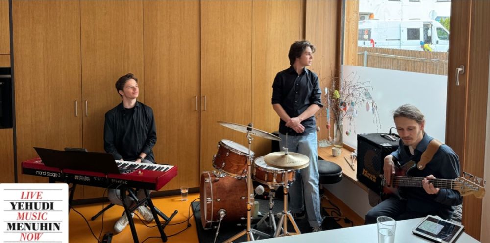 drei Musiker mit Keyboard, Schlagzeug und E-Gitarre